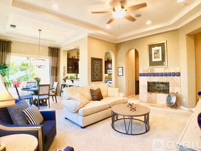 A living room with a fireplace and a ceiling fan.