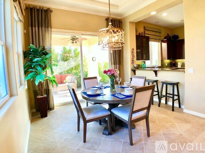 A dining room with a table set for two and a bar area in the background.