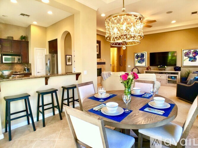 A dining room with a round table set for six.