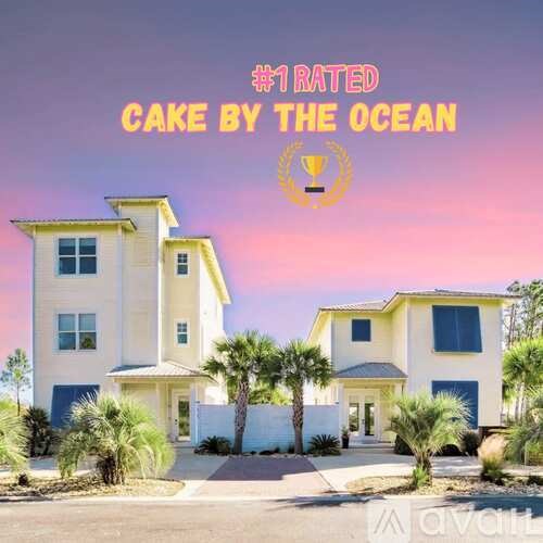 A large two-story house with a white exterior and a yellow roof is labeled as the "#1 RATED CAKE BY THE OCEAN".