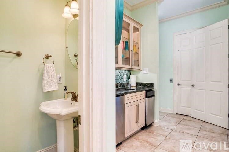 A bathroom with a sink, mirror, and cabinets.