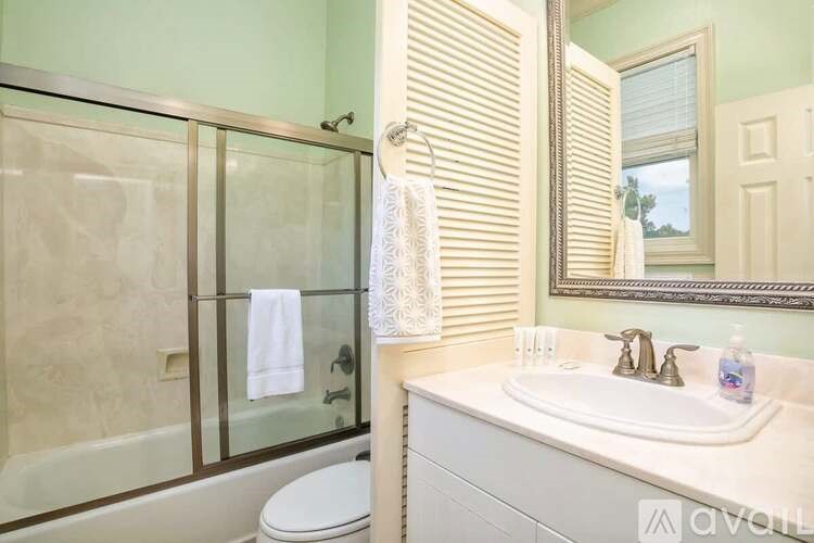 A bathroom with a toilet, sink, and shower.