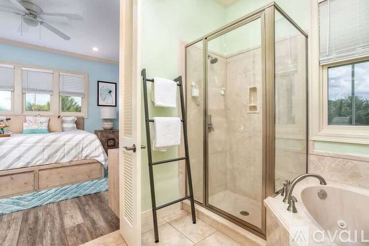 A bathroom with a glass shower door and a bathtub.