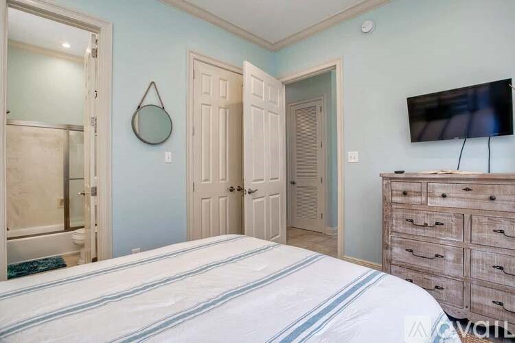 A bedroom with a bed, dresser, and mirror.