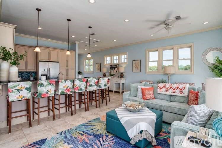 A living room with a couch, chairs, and a rug.