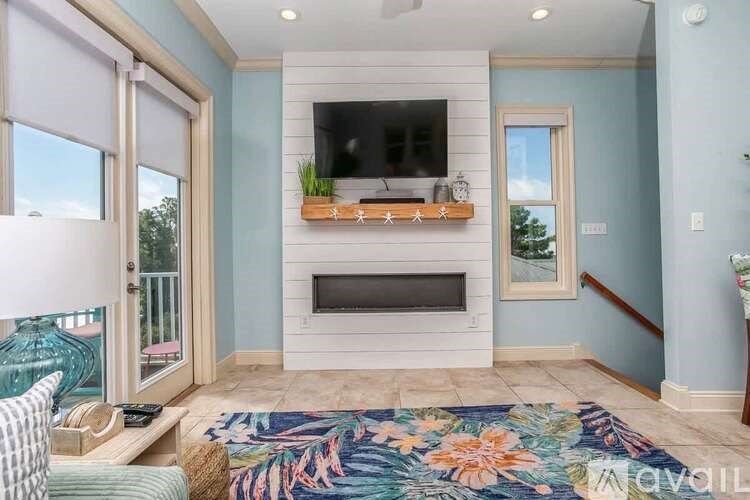 A living room with a fireplace and a flat screen TV mounted above it.