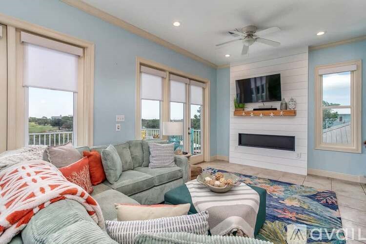 A living room with a grey couch and a television on the wall.