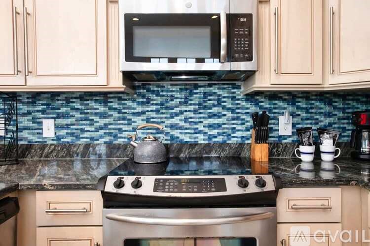 A kitchen with a stove, oven, microwave, and cabinets.
