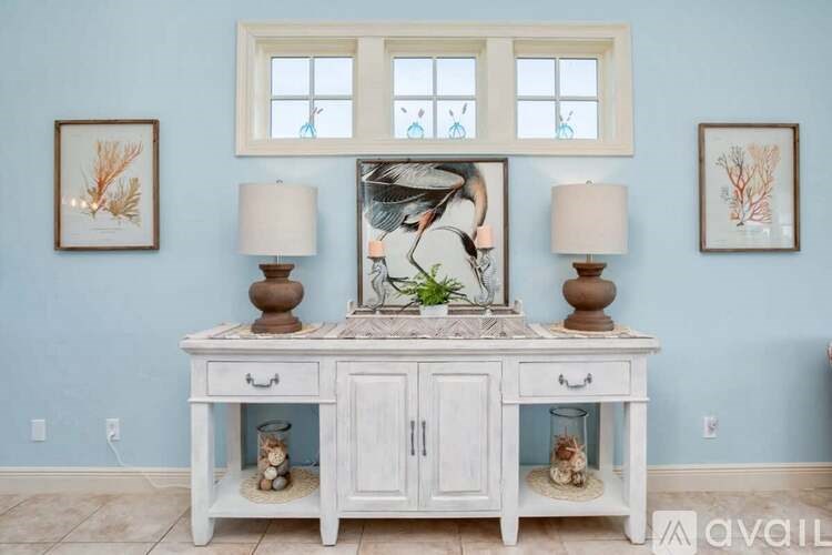 A white desk with a framed picture of a woman on it.