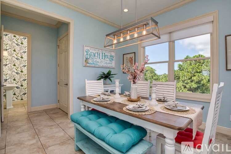 A dining room with a table set for two and a view of the backyard.