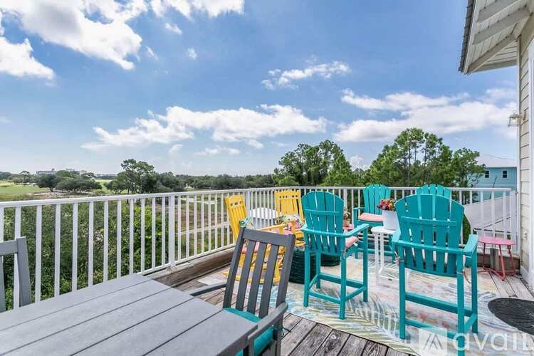 A balcony with a table and chairs overlooking a green landscape.