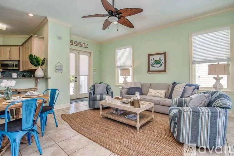 A living room with a striped couch and a dining table with blue chairs.