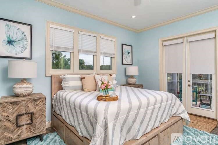A bedroom with a bed, dresser, and window with white blinds.
