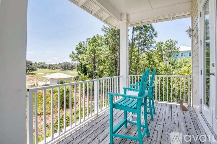 A balcony with a blue chair and a white railing.