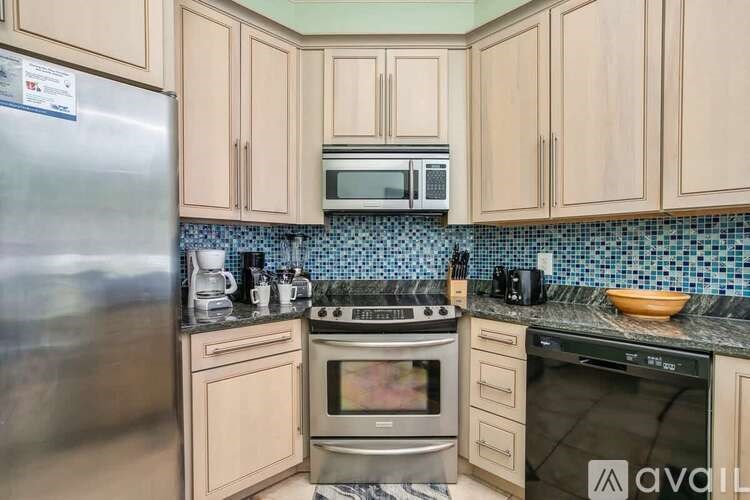 A kitchen with wooden cabinets and a stainless steel refrigerator.