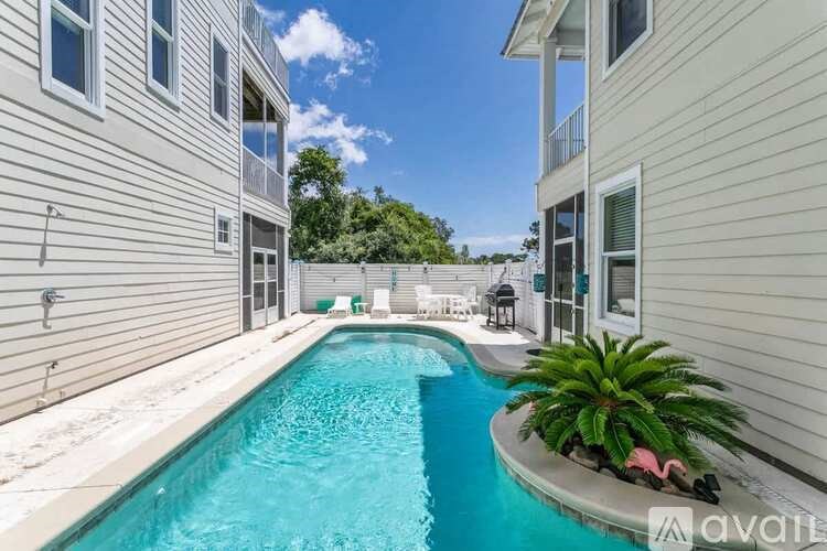 A small pool in a residential area surrounded by houses.