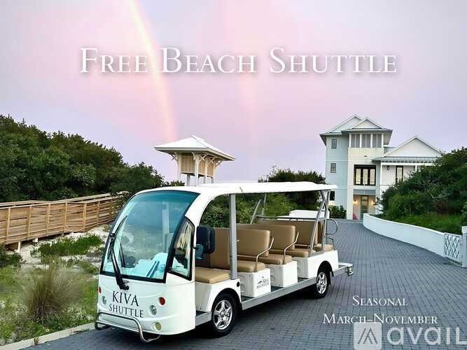 A white shuttle bus with the name Kiva on it is parked in front of a house.