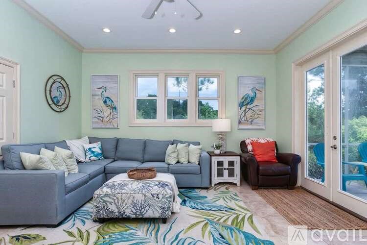 A living room with a grey couch, a brown coffee table, and a green rug.