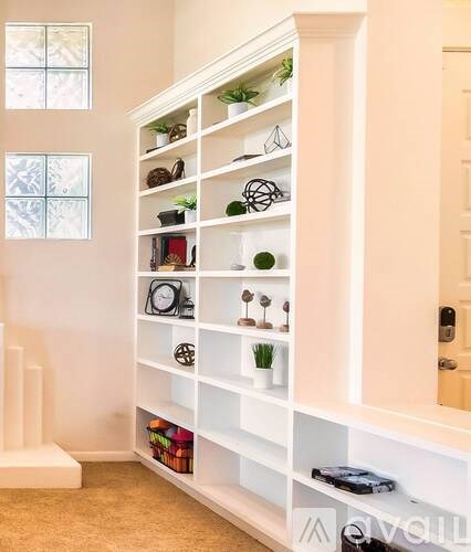 A white shelving unit with various decorative items on it.