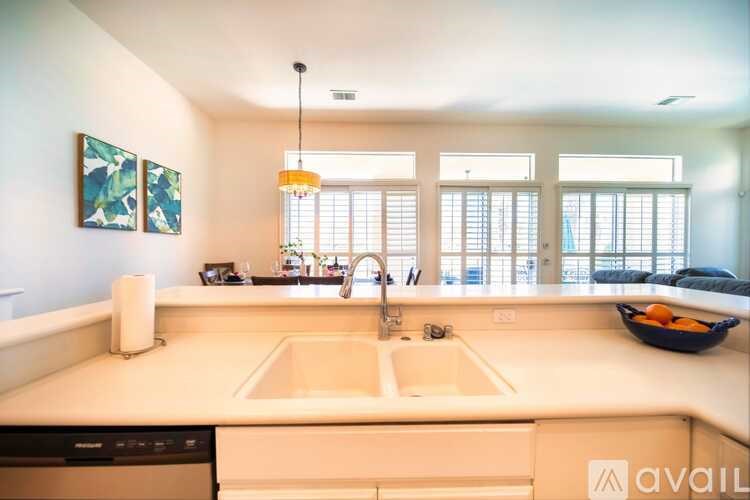 A kitchen with a white countertop and a bowl of fruit on it.
