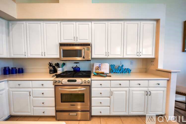 A kitchen with white cabinets and a stove top oven.