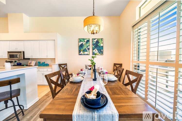 A dining room with a wooden table set for a meal.