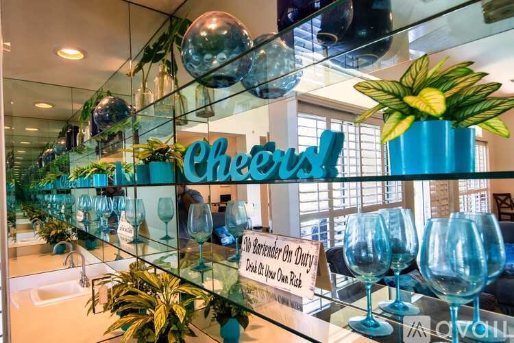 A glass display case with a sign that says "Cheers!" and a sign below it that says "All customers must wear a mask while in our store."