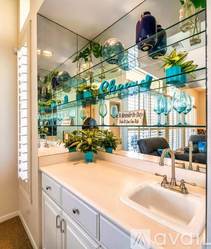 A bathroom with a white counter and a mirror with a sign that says "Cheers".