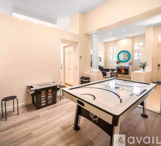 A pool table is in the middle of a room with a cabinet and a plant.
