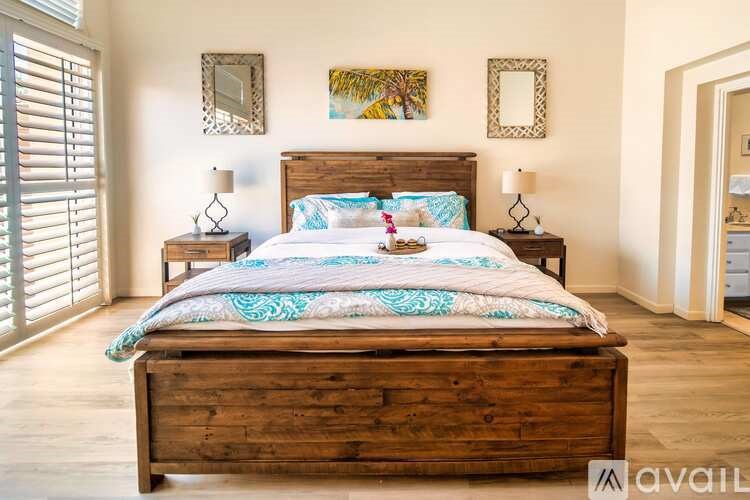 A bedroom with a large bed and wooden headboard.
