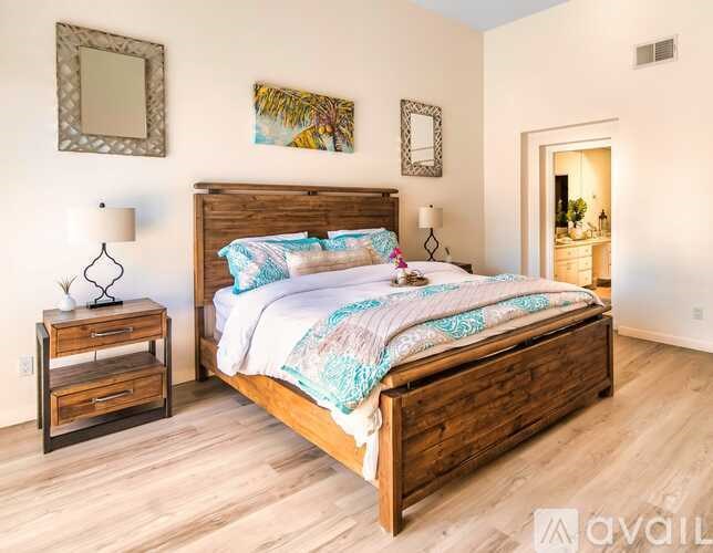 A bedroom with a large bed and a wooden nightstand.