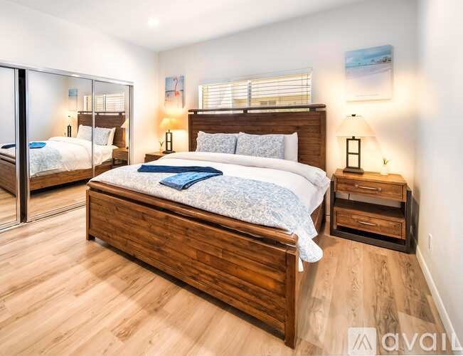 A bedroom with a large bed and wooden furniture.