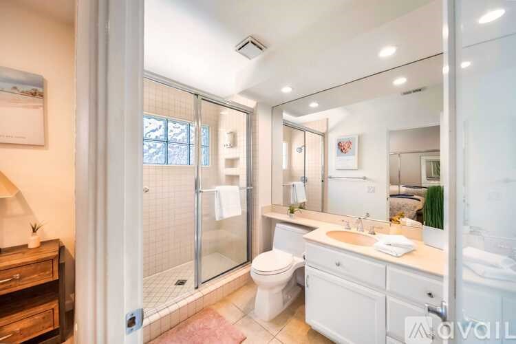 A bathroom with a toilet, sink, and shower.