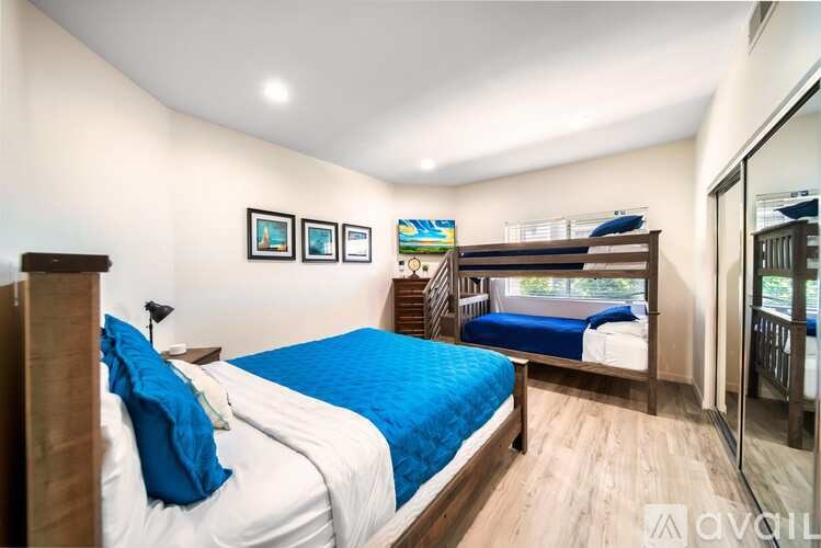 A bedroom with a bed, a bench, and pictures on the wall.