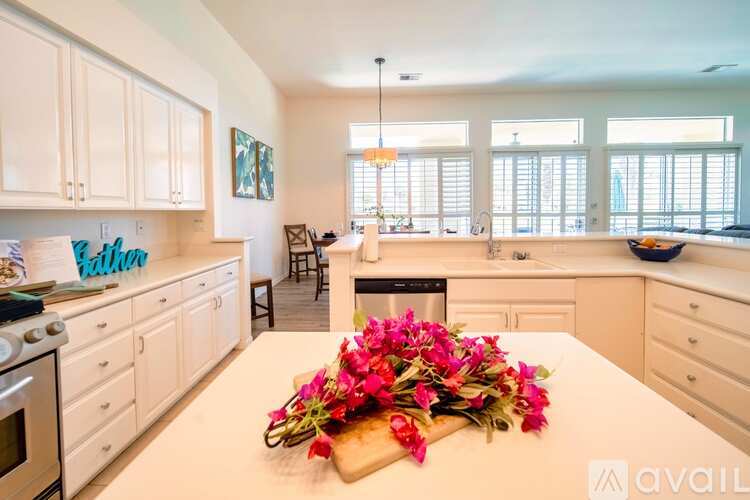 A kitchen with a white table and a bouquet of flowers on it.