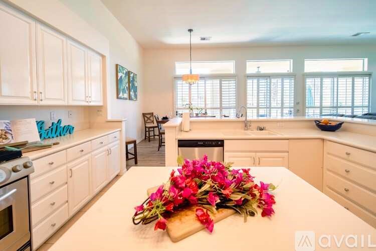 A kitchen with a white table and a bouquet of flowers on it.
