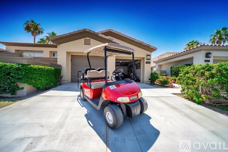 A red golf cart is parked in front of a house.
