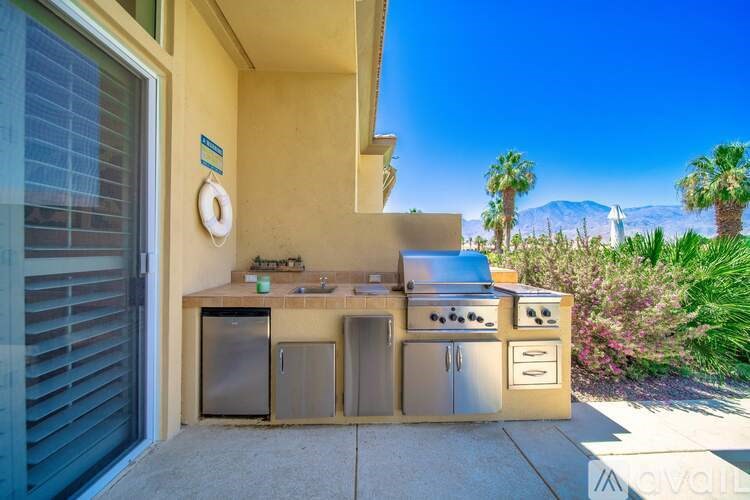 A stainless steel outdoor kitchen with a grill and sink.