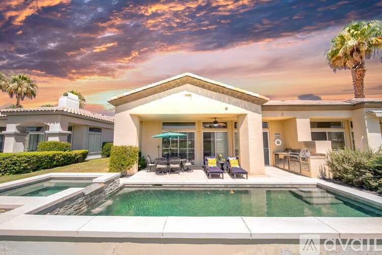 A house with a pool in front of it.
