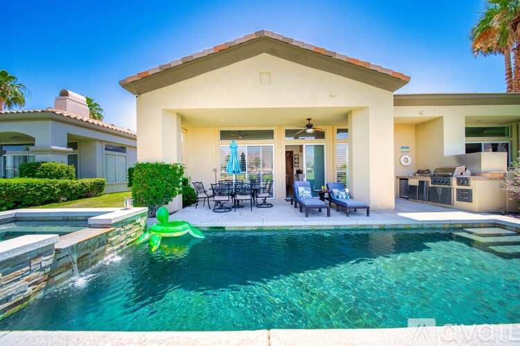 A house with a pool and a green inflatable in the water.