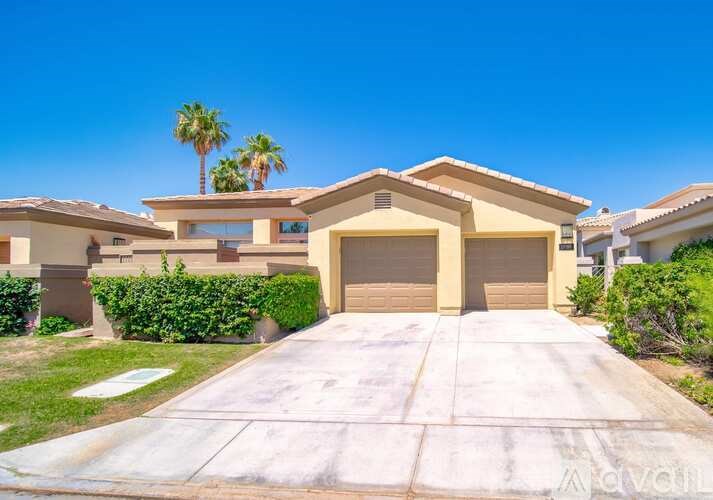 A house with a driveway and garage doors in front of it.
