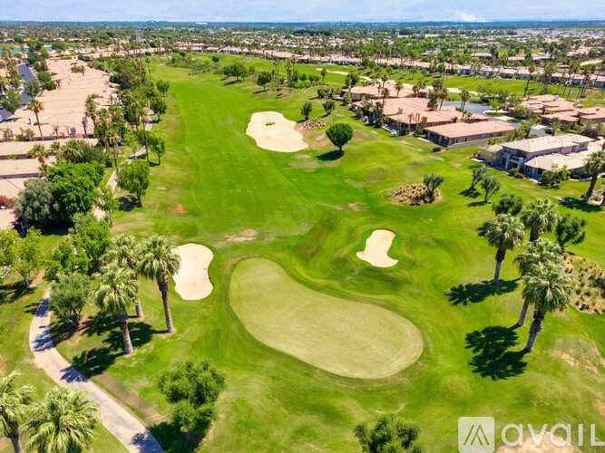 A golf course with a green and a white sand trap.