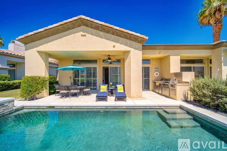 A house with a pool in front of it.