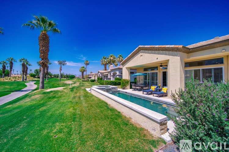 A house with a pool and palm trees in the background.