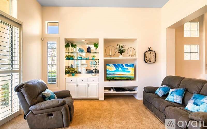 A living room with a grey couch, a brown chair, and a television.