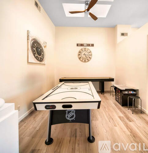 A room with a pool table and a clock on the wall.