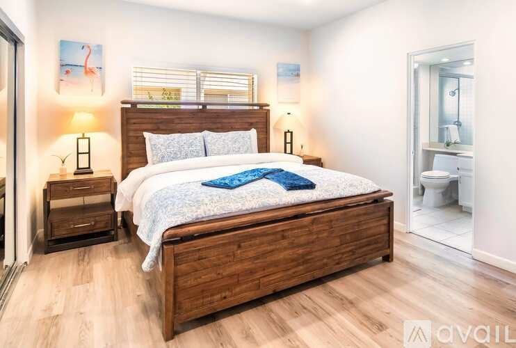 A bedroom with a large bed and a wooden headboard.