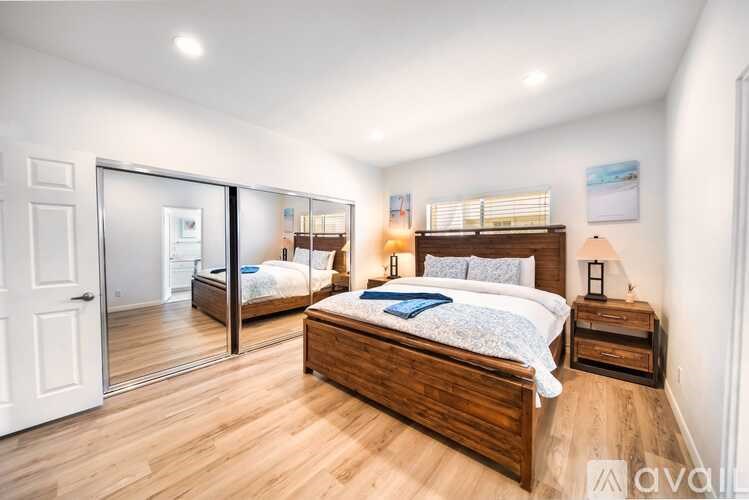 A bedroom with a large bed and wooden floors.