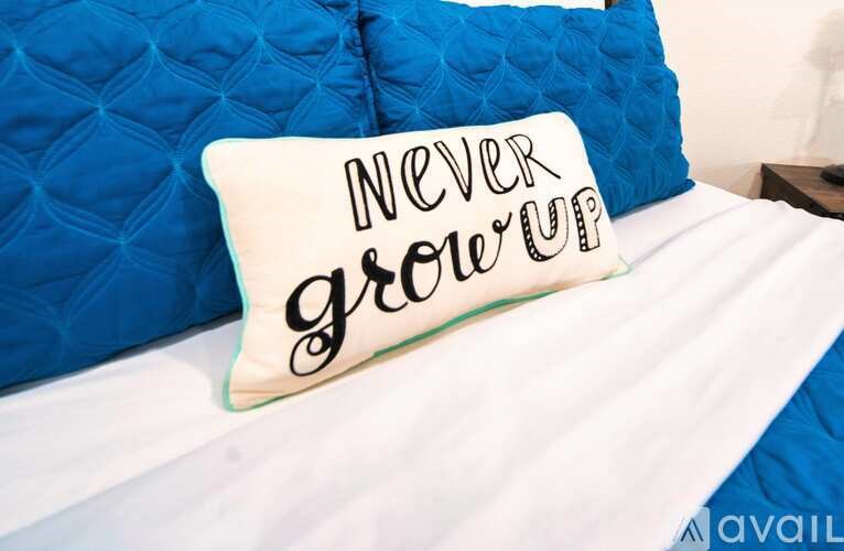 A white pillow with the words "NEVER grow up" written on it.