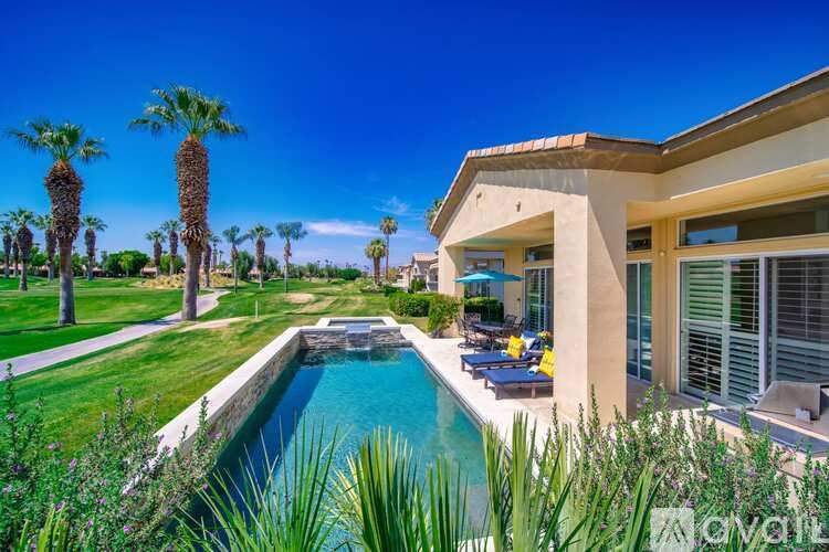A house with a pool and palm trees in the yard.